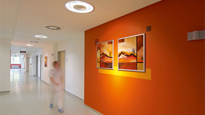 Enfermeira a caminhar num corredor iluminado pela Philips na clínica psiquiátrica