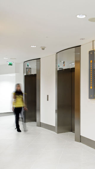 Corredor e elevadores no edifício da Tower 42, iluminados por iluminação de escritório Philips