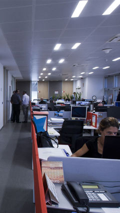 Funcionários a trabalhar de forma eficiente sob luzes LED economizadoras da Iluminação Philips na E.ON, Espanha