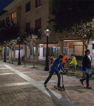 Pessoas a caminhar à noite pelas ruas de Palência iluminadas por iluminação Philips