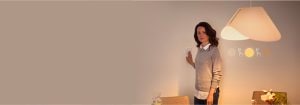 "Mulher ajustando um interruptor de dimmer inteligente, controlando o ambiente de iluminação LED quente em um espaço de estar contemporâneo com decoração minimalista"