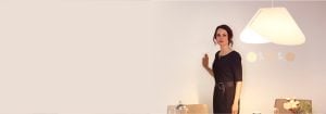 "Mulher ajustando iluminação embutida de LED brilhante por meio de um elegante dimmer montado na parede, melhorando o ambiente e a eficiência energética da sala de estar moderna."