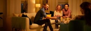 "A iluminação LED quente cria um ambiente aconchegante para amigos socializando na sala de estar, destacando a iluminação com eficiência energética para reuniões noturnas."