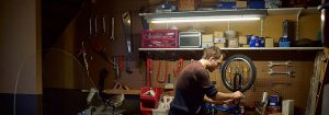 "Lâmpada tubular de LED iluminando o interior da garagem, exibindo iluminação de baixo consumo de energia para espaços de armazenamento com bicicletas e utensílios domésticos."