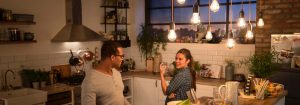 "Cozinha moderna com Luz suspensa LED de estilo vintage iluminando duas mulheres desfrutando de um jantar, criando uma atmosfera acolhedora e convidativa."