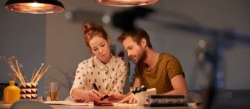 Casal trabalhando junto na mesa de jantar