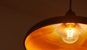 "Lâmpada de filamento LED de estilo vintage em luminária pendente, emitindo um brilho dourado quente, exibindo uma iluminação nostálgica e com baixo consumo de energia para um ambiente aconchegante em casa."