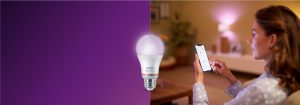 "Mulher controlando iluminação LED inteligente via aplicativo de smartphone, criando um ambiente aconchegante em uma sala de estar com tecnologia de casa inteligente."