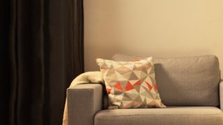 Sala de estar aconchegante com luminária de mesa LED moderna, iluminando o sofá cinza e criando um ambiente aconchegante para relaxamento em casa.